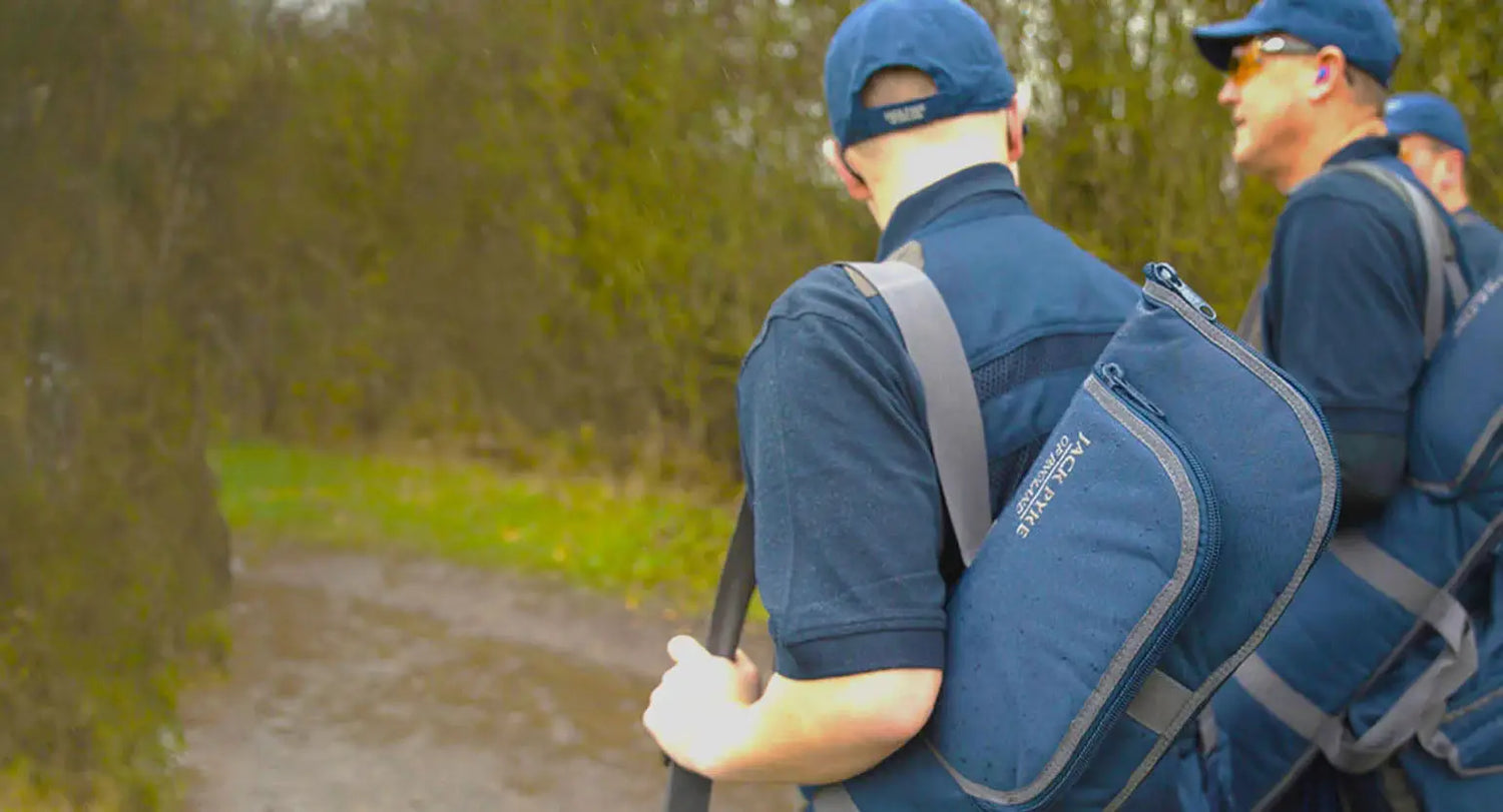 Two people in blue uniforms with backpacks, showcasing Jack Pyke accessories in action.