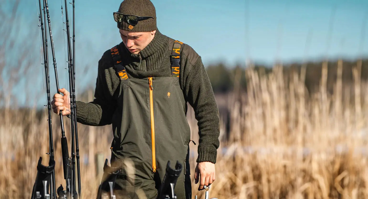 Hunter in forest clothing with fishing rods, ready for an epic fishing adventure.