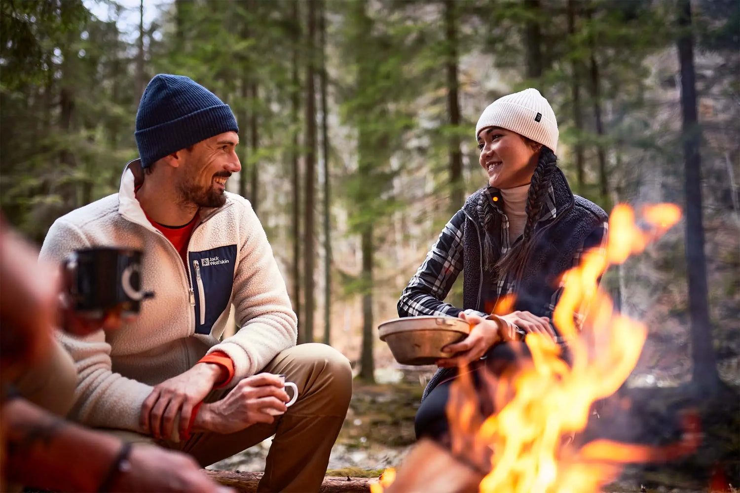 Campfire flames in foreground, perfect for outdoor adventures with Jack Wolfskin country clothing.