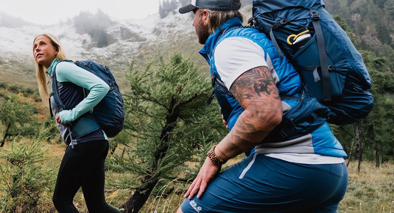 Two hikers on a mountain trail with Jack Wolfskin rucksacks ready for adventure.