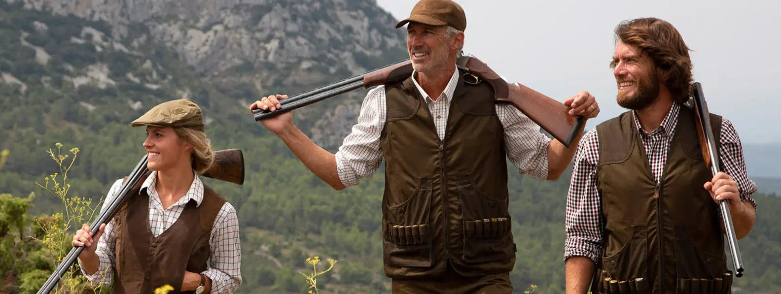 Three men in hunting clothing carry rifles while enjoying the outdoors, ready for adventure.