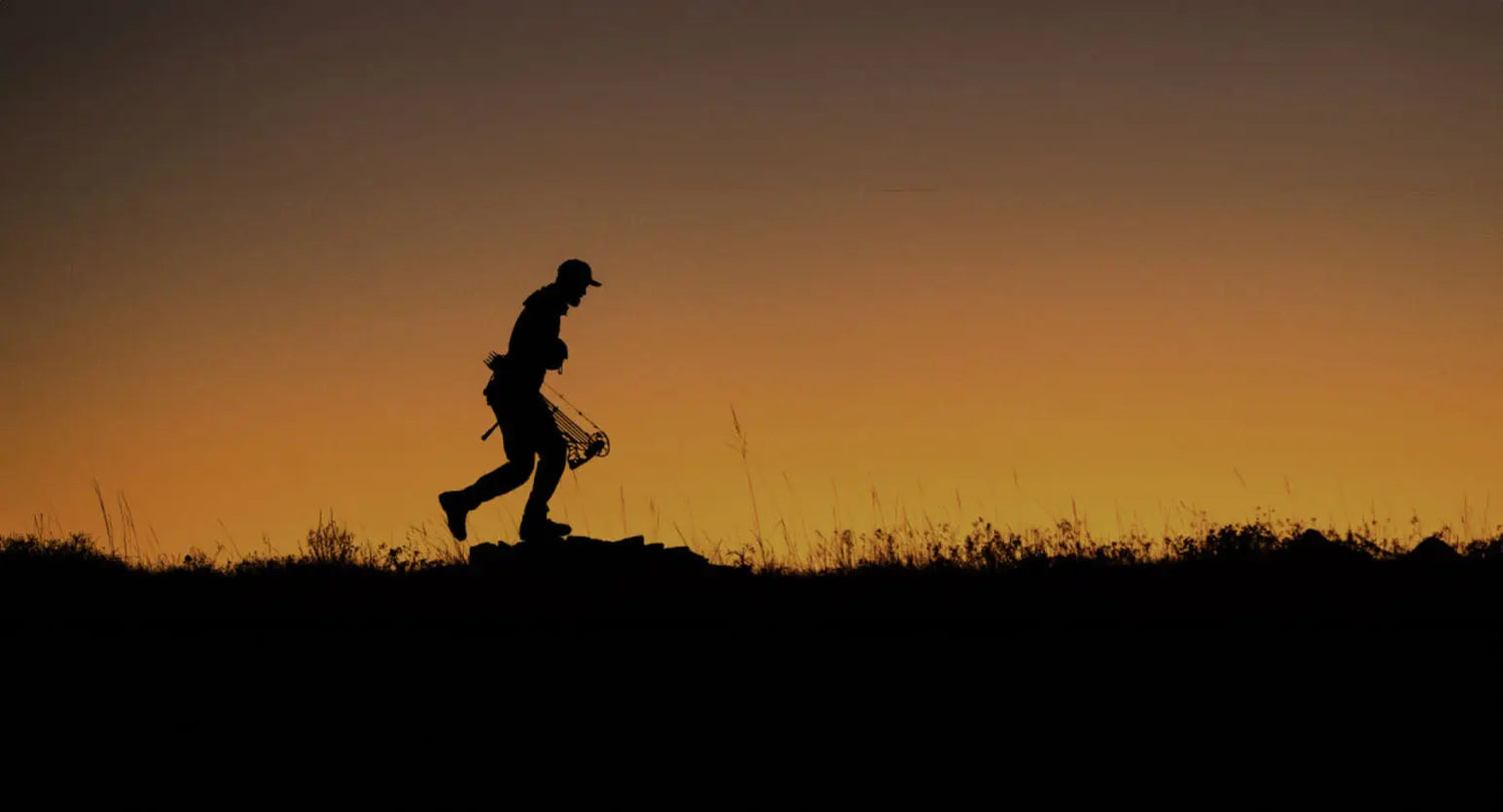 Silhouette of a runner on a hill at sunset, embracing Sitka stands tall spirit.