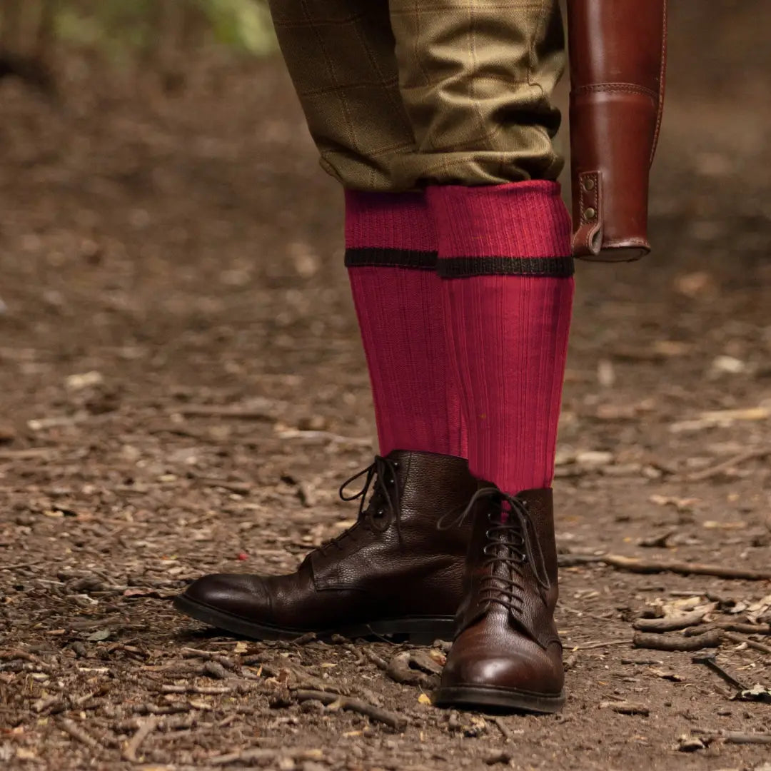 Dark leather boots paired with bright red House of Cheviot Estate Field Socks