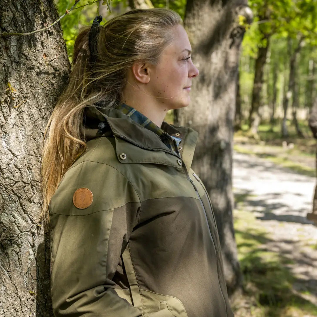 Woman in an olive green jacket enjoying the outdoors, ideal for country clothing and hunting