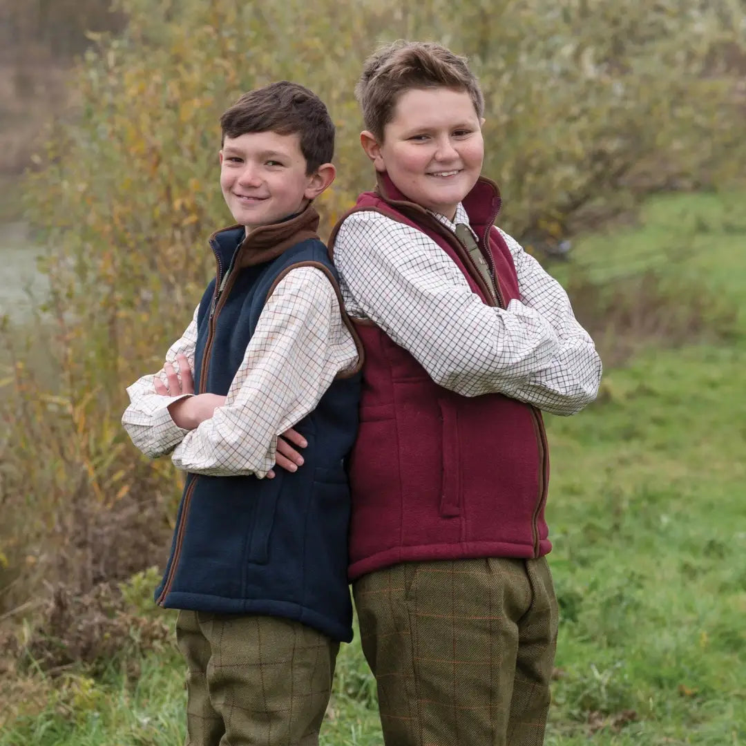 Two boys back-to-back in the Alan Paine Aylsham children’s fleece waistcoat outdoors