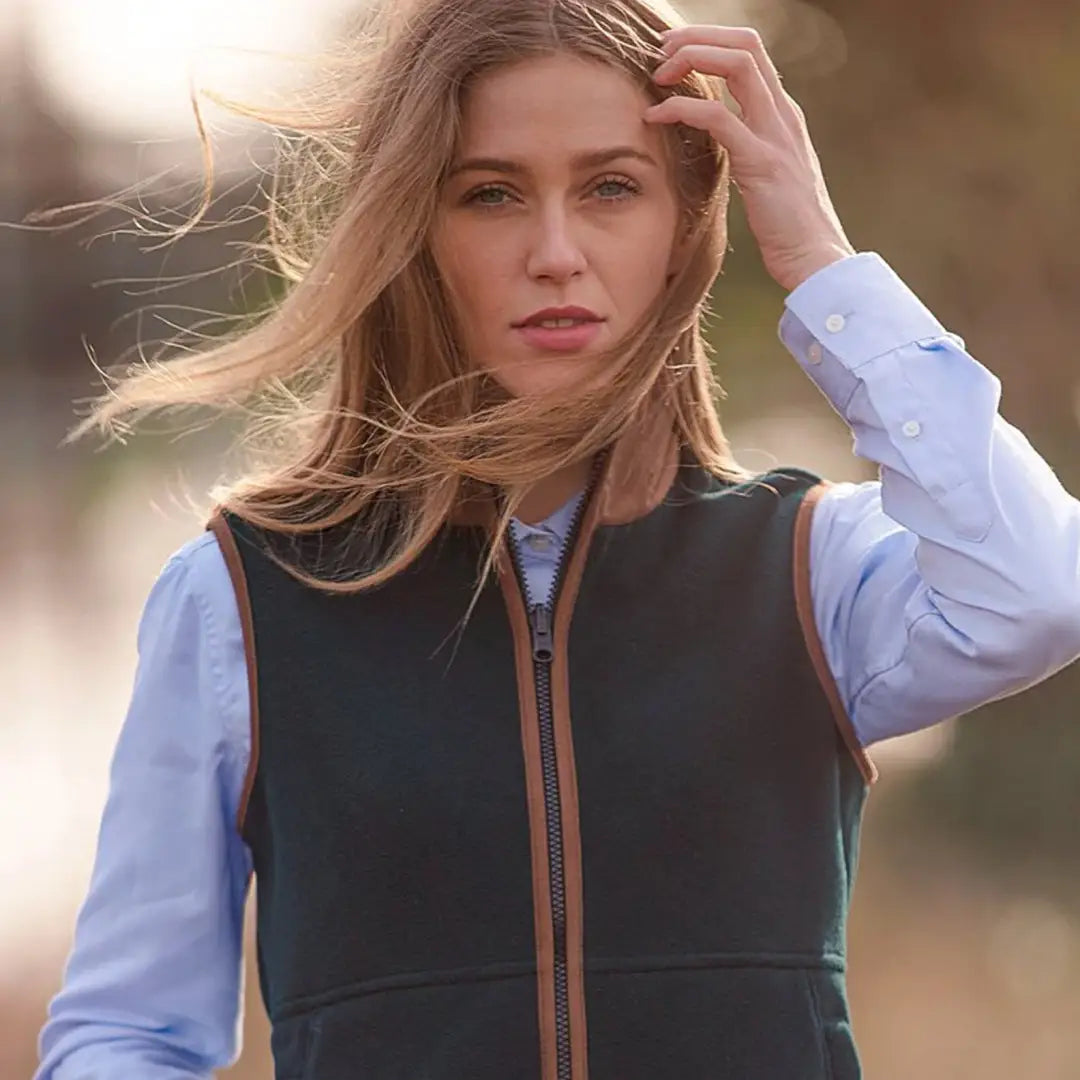 Woman in a dark vest and blue shirt showcases Alan Paine Aylsham Ladies Fleece Gilet