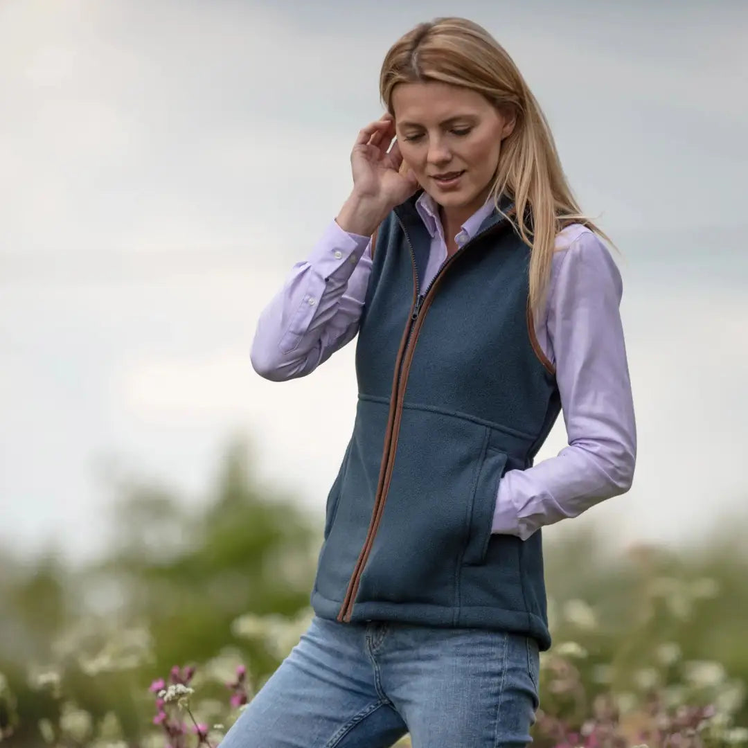 Woman in navy blue Alan Paine Aylsham fleece gilet over light purple shirt