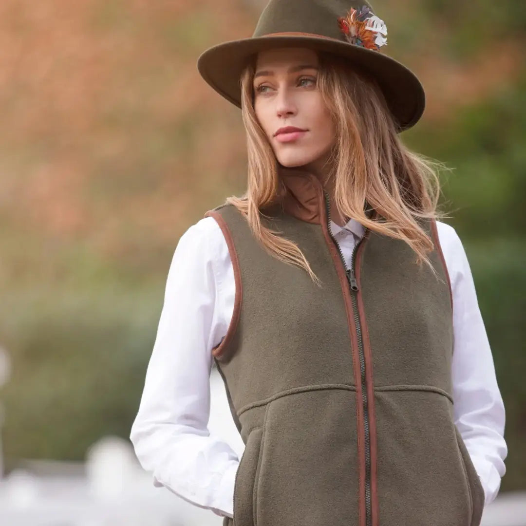 Woman in brown hat and olive green vest wearing Alan Paine Aylsham Ladies Fleece Gilet