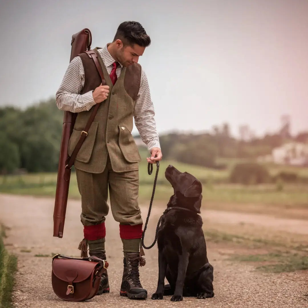 Man in traditional hunting gear with black Labrador wearing Alan Paine Combrook tweed breeks