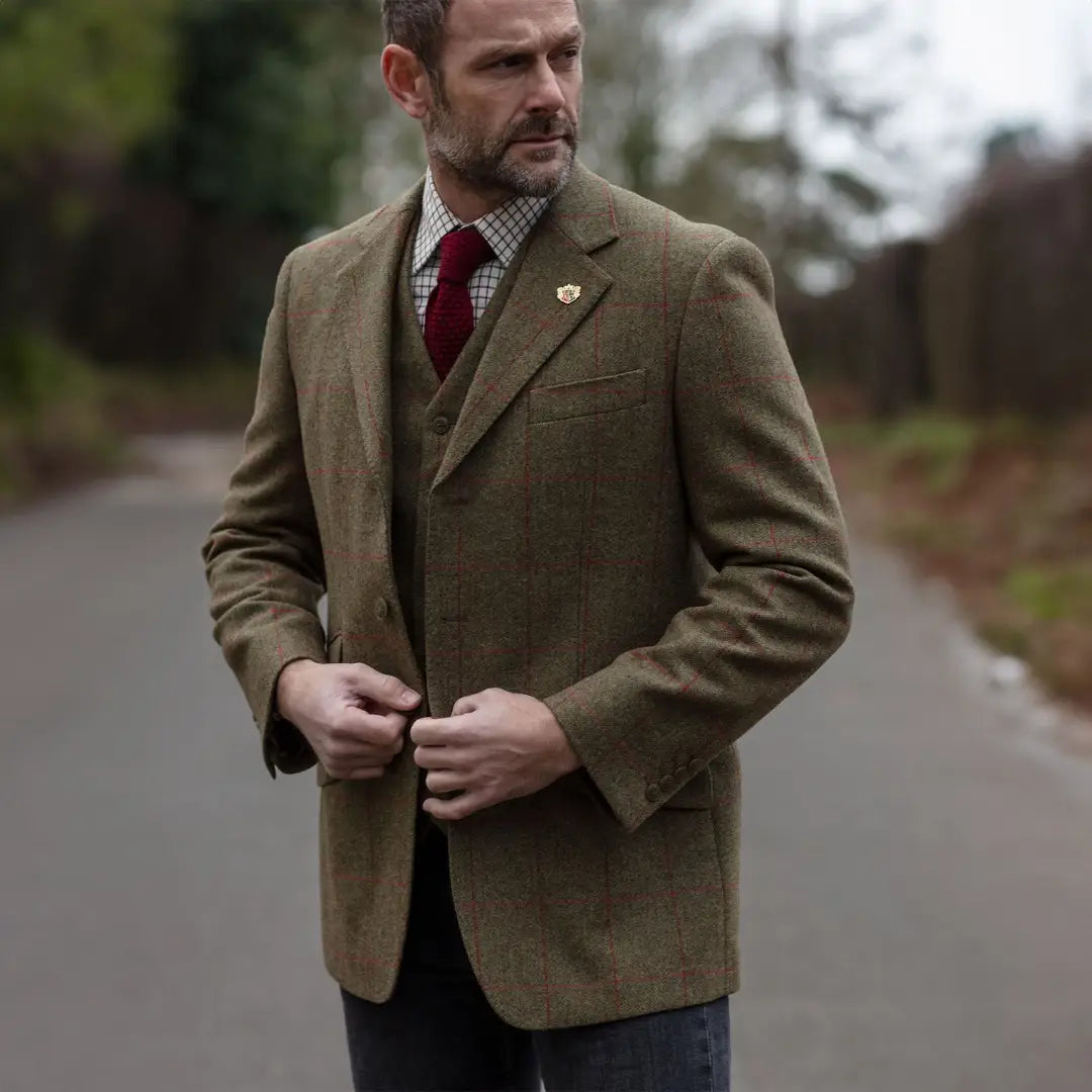 Middle-aged man in a tan tweed blazer and red tie showcasing Alan Paine Combrook style