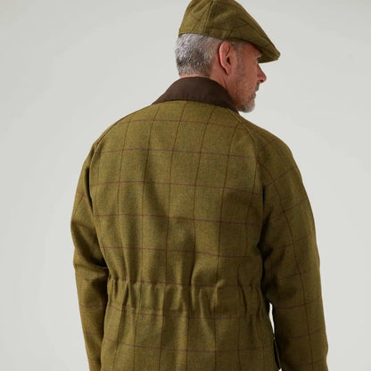 Person wearing an Olive Green quilted jacket and cap, featuring Alan Paine’s Rutland Waterproof Tweed