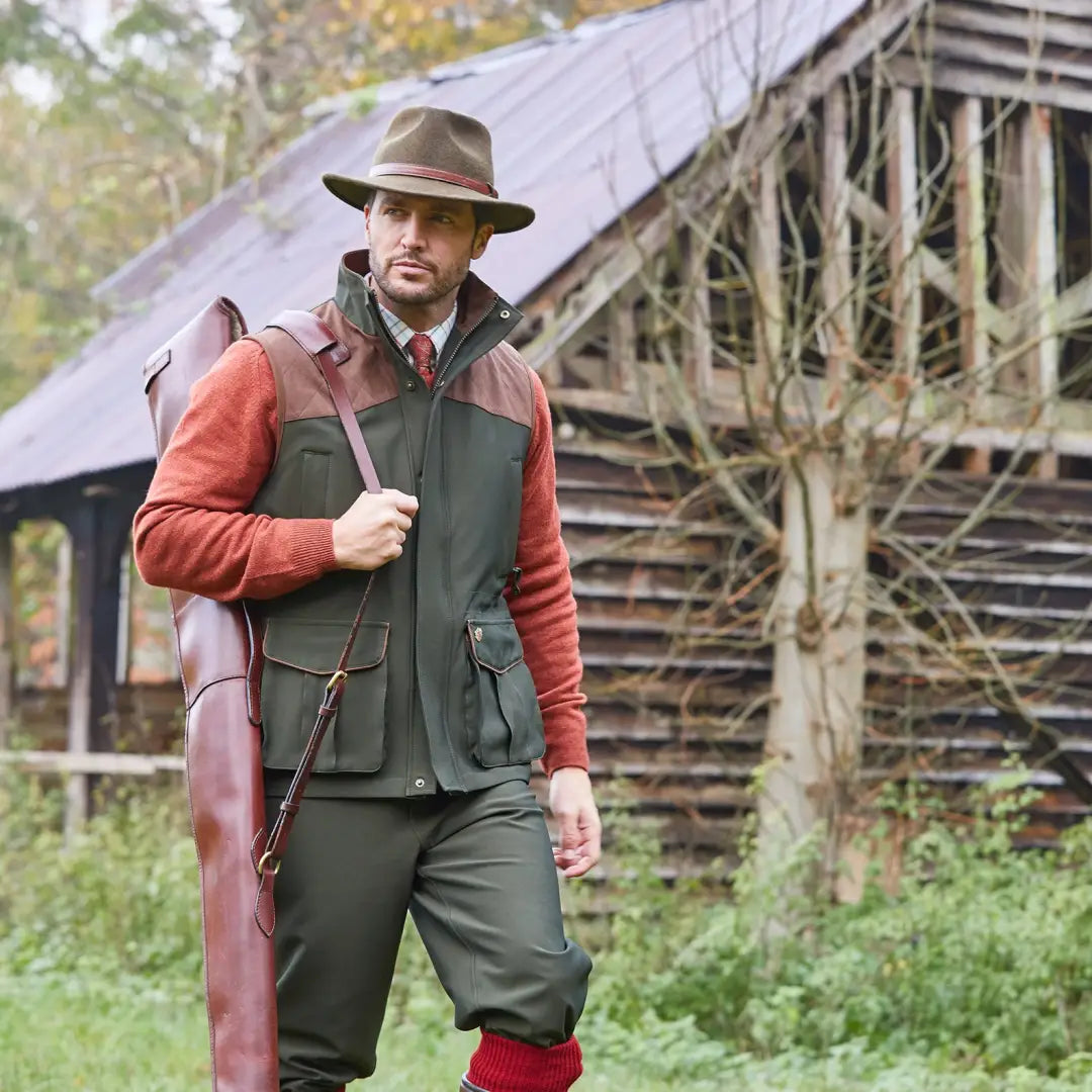 Man in hunting attire with Alan Paine Stancombe Waistcoat near rustic structure in outdoors