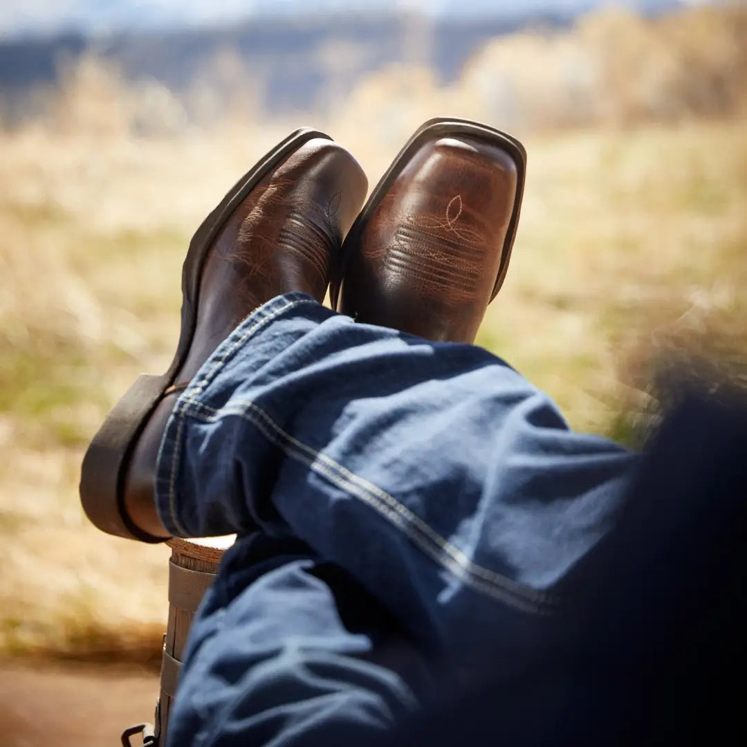 Brown leather Ariat Rambler Western Boots paired with blue jeans for country clothing vibes