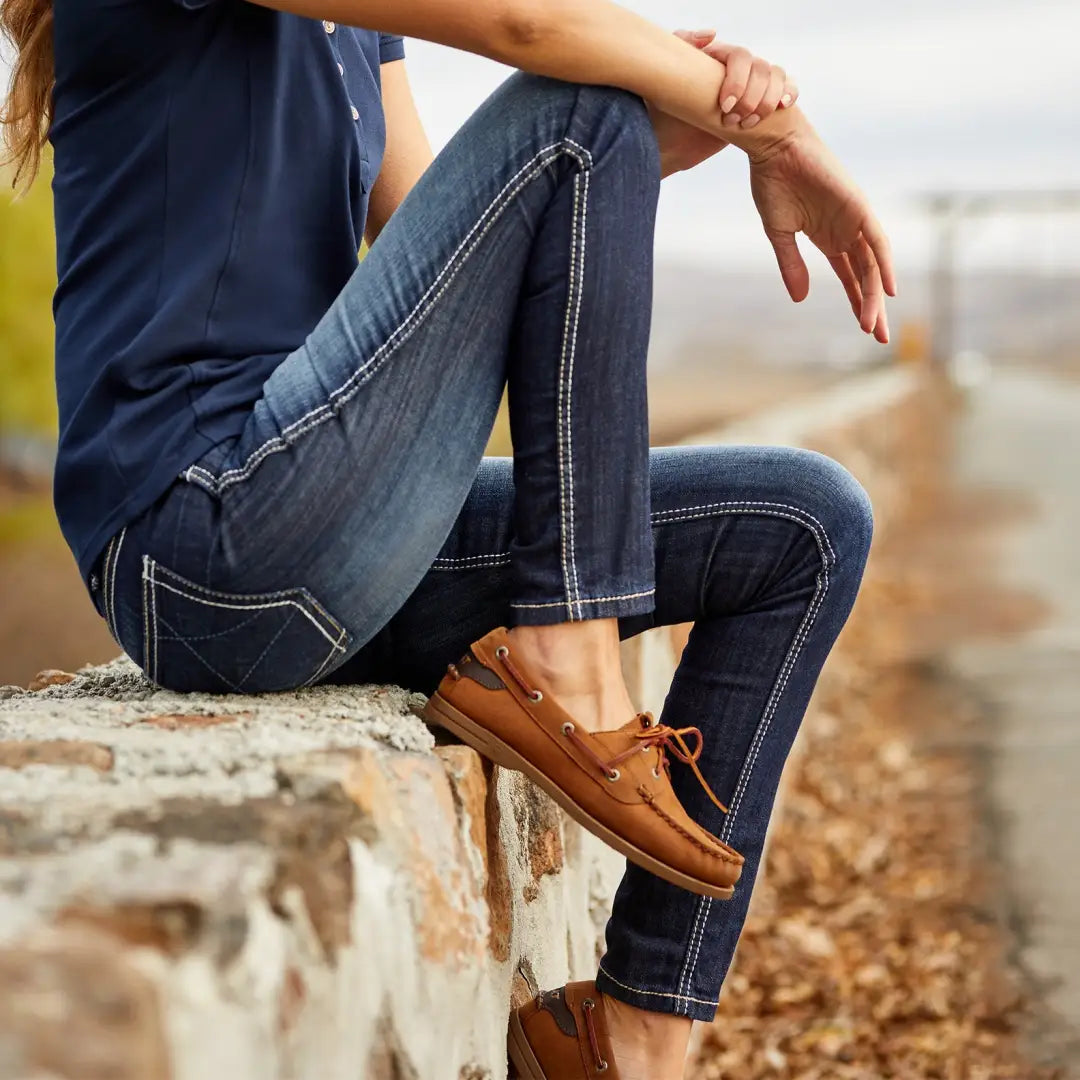 Person in blue jeans and brown boat shoes styled with Ariat Womens Antigua Boat Shoes