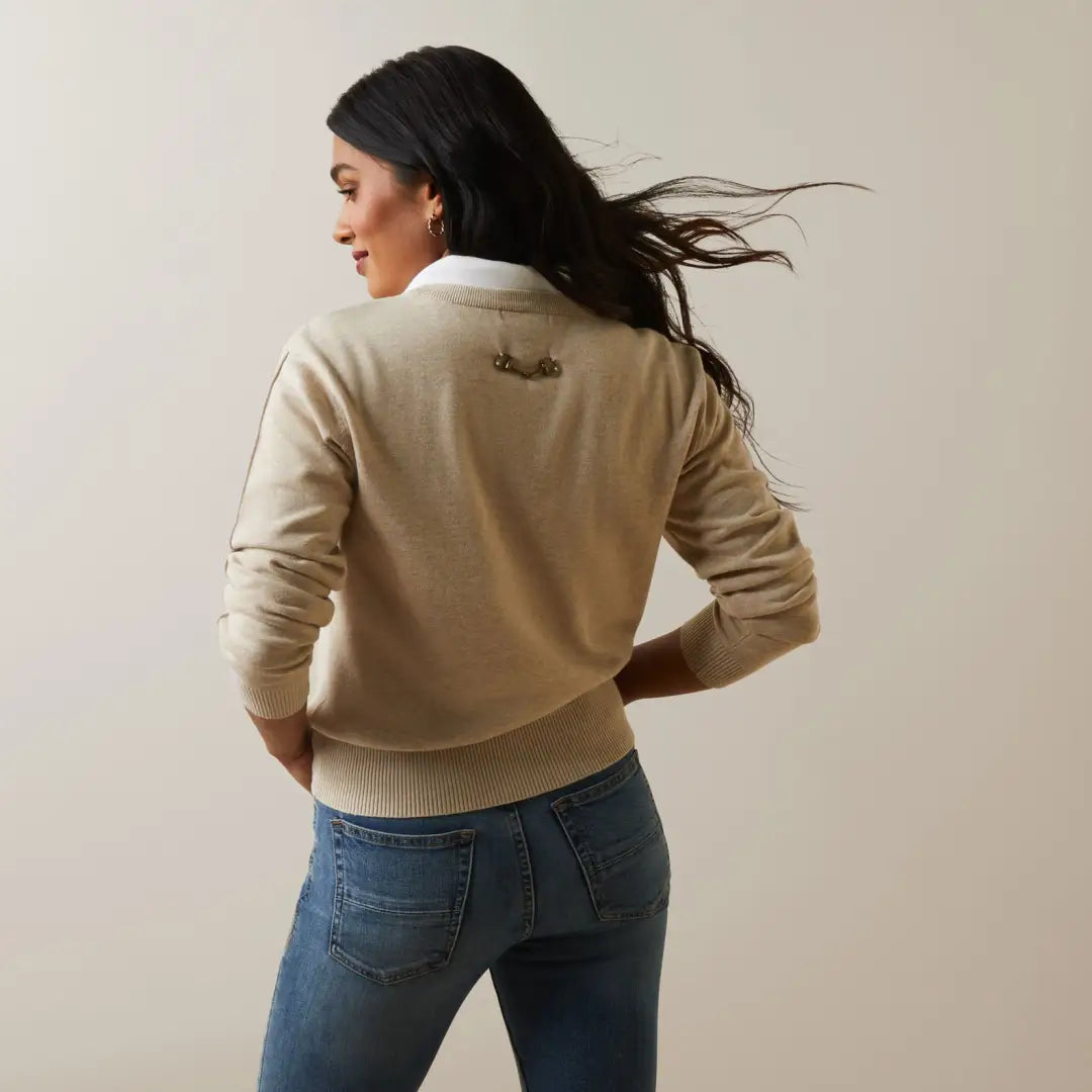 Woman in beige sweater and blue jeans showcasing Ariat Womens Peninsula Sweater for outdoor style