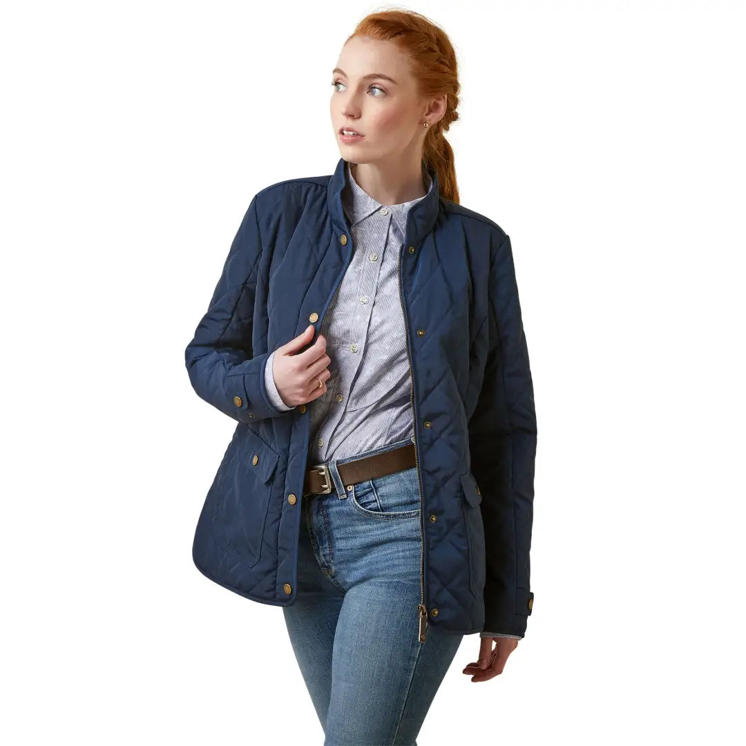 Navy blue quilted jacket over a light shirt and jeans, featuring recycled polyester shell