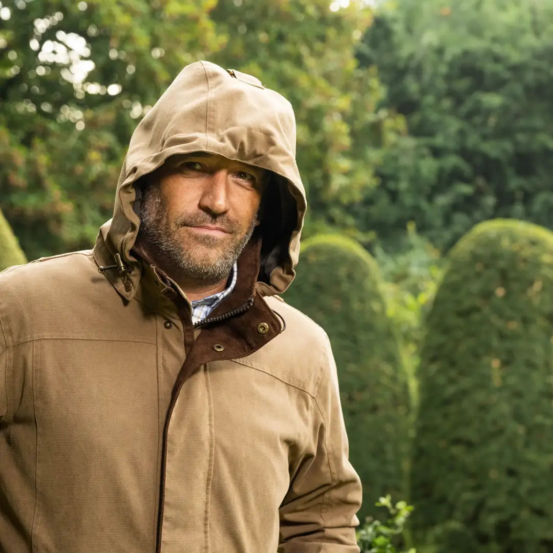 Middle-aged man in tan hooded jacket outdoors, perfect for country clothing adventures