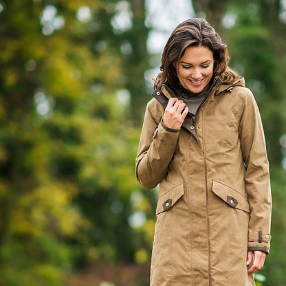 Woman in a tan trench coat outdoors, showcasing the Baleno Chelsea Waterproof Coat