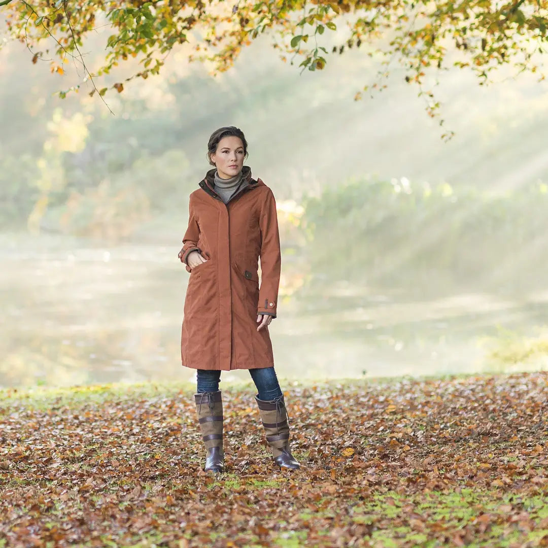 Person rocking a Baleno Chelsea Waterproof Coat with brown boots on autumn leaves