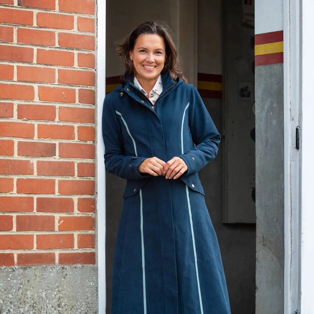 Woman in a long blue coat standing in a doorway, rocking the Kensington Safe style