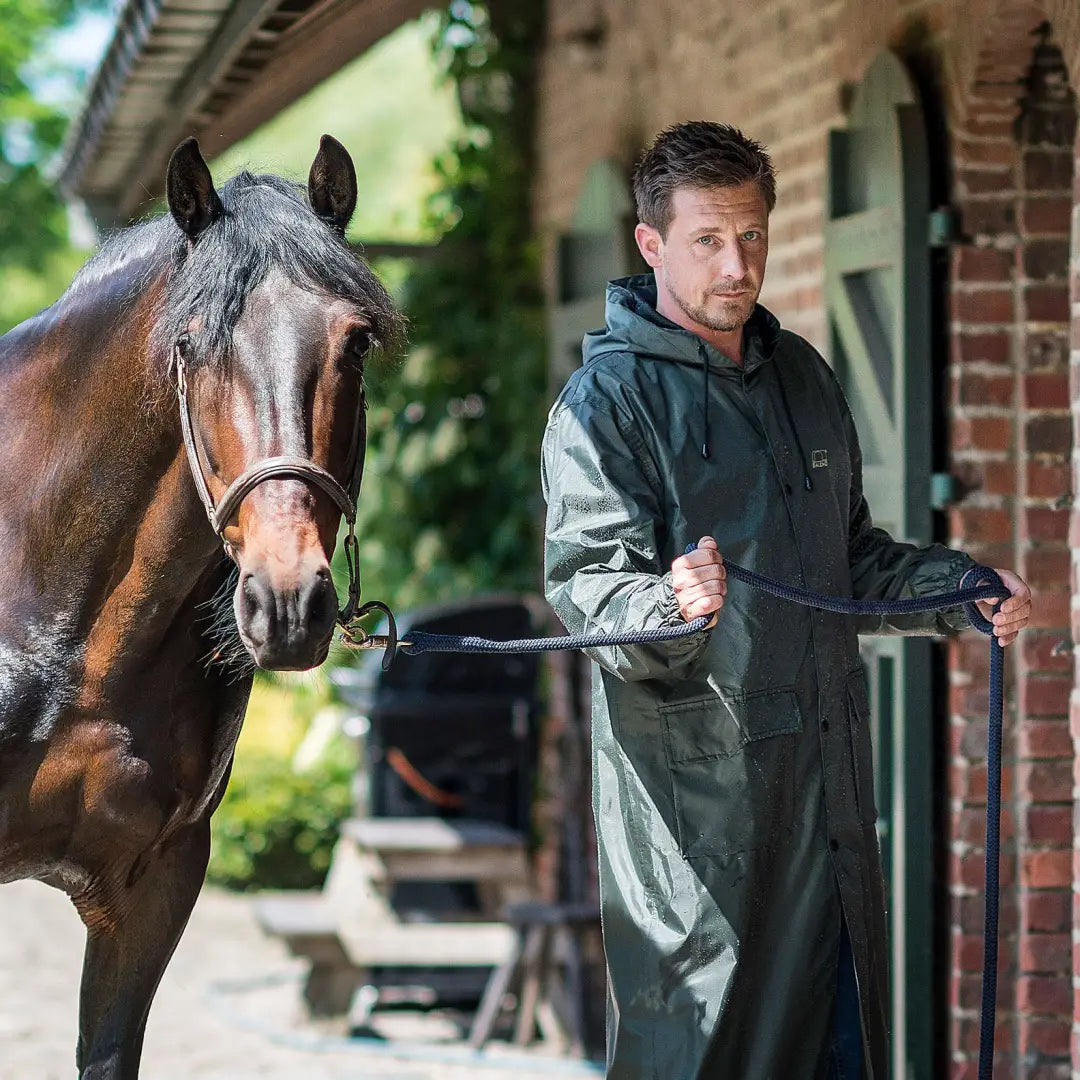 Brown horse next to a person in a comfy Baleno Montana Raincoat with adjustable fixed hood