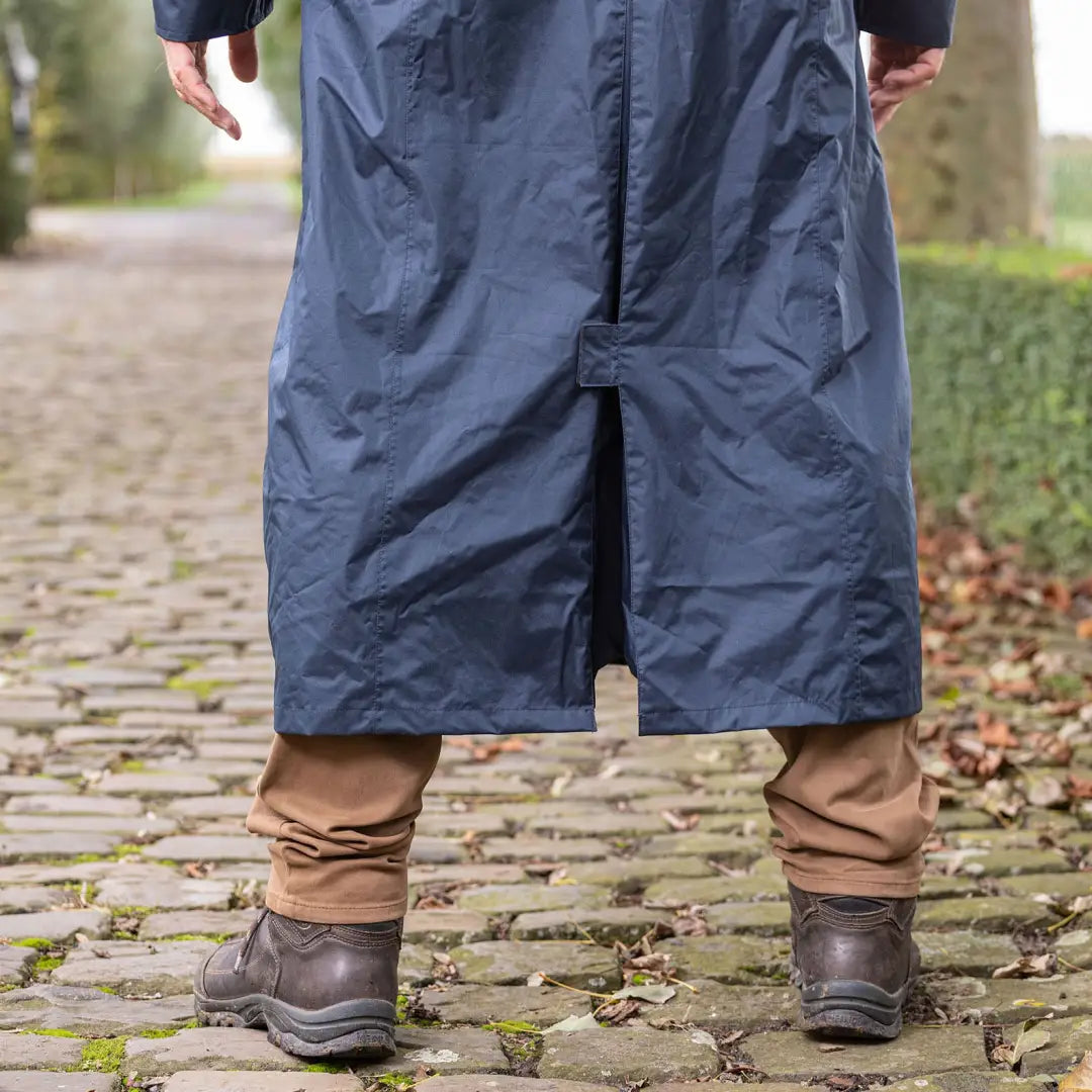 Long navy blue Baleno Newbury men’s jacket over brown pants and dark boots