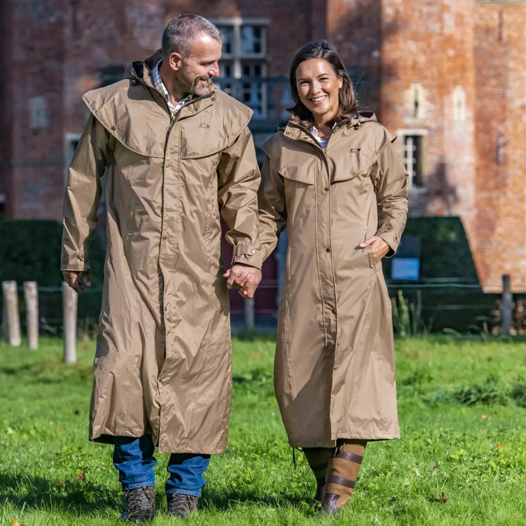 Couple in Long Beige Baleno Oxford Ladies Full Length Coats walking on grass