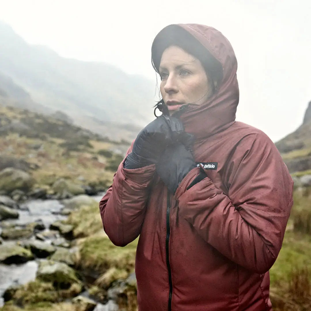 Person in a red outdoor jacket showing off Buffalo Mitts in a misty Scottish winter route