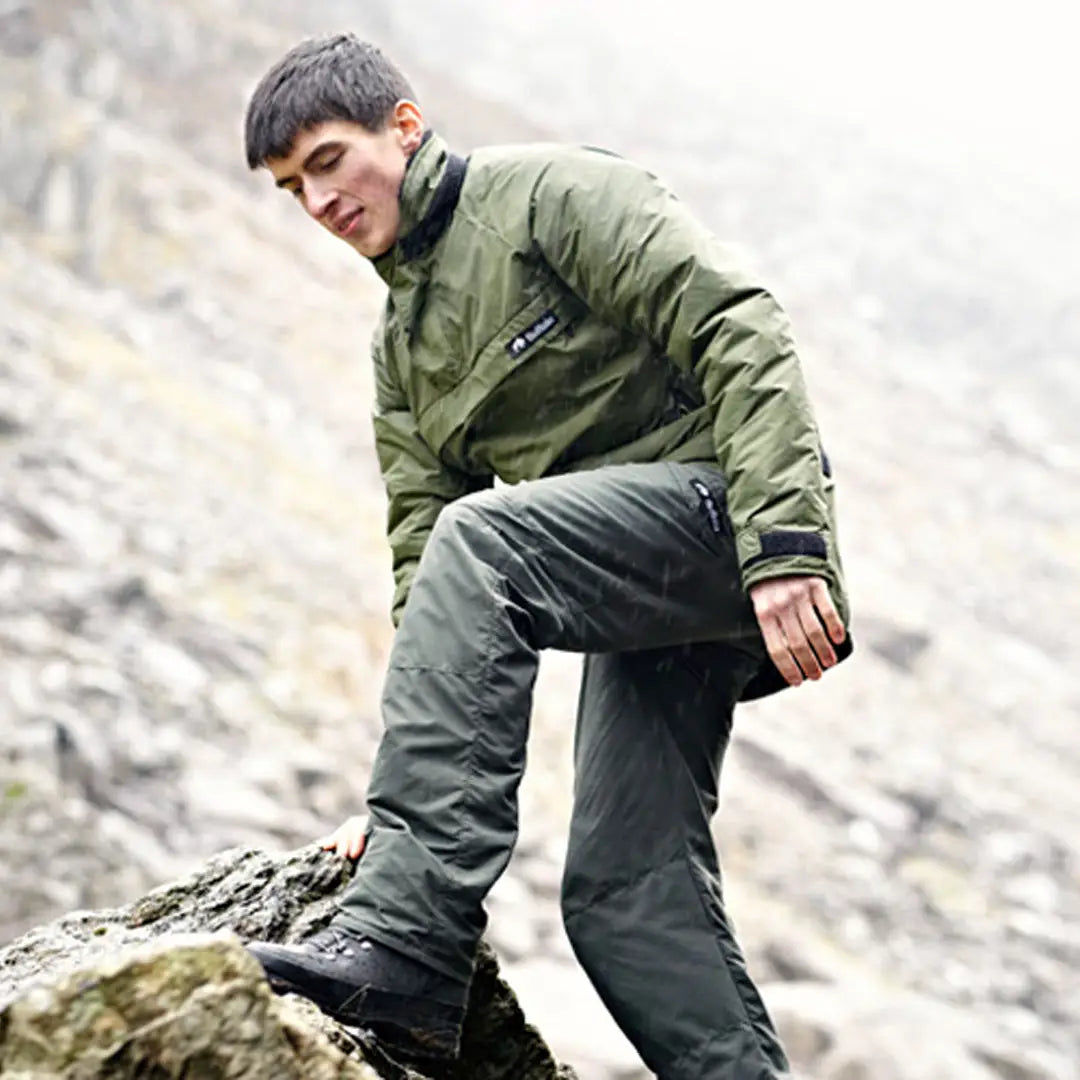 Young man in a green Buffalo Mountain Shirt on rocky terrain, styled with gray pants