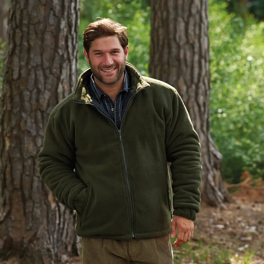 Man in a dark green Champion Glen Padded Fleece jacket in a forest