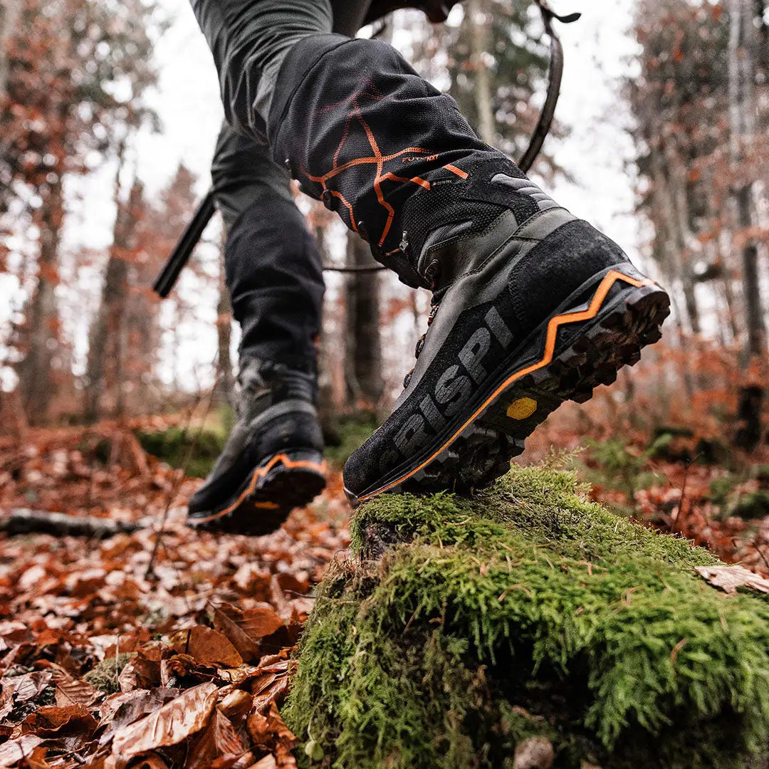 Crispi Futura NXT GTX stepping on moss-covered rock amidst colorful autumn leaves