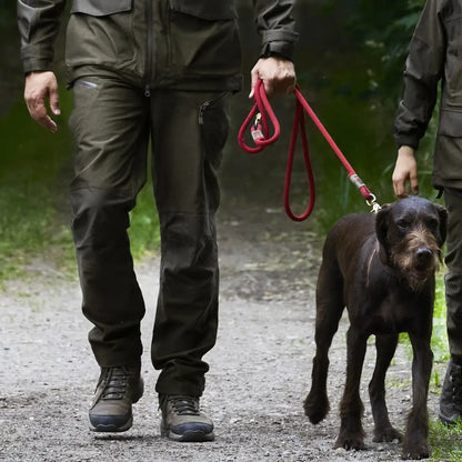 Black dog on a red leash on a path, showcasing Deerhunter Chasse Trousers in action