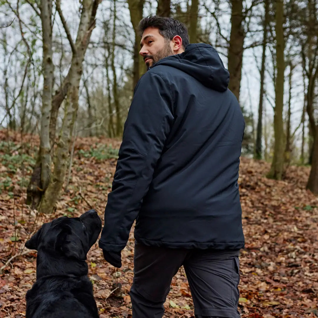 Person in a black Deerhunter Denver Winter Jacket walking a dog in a forest