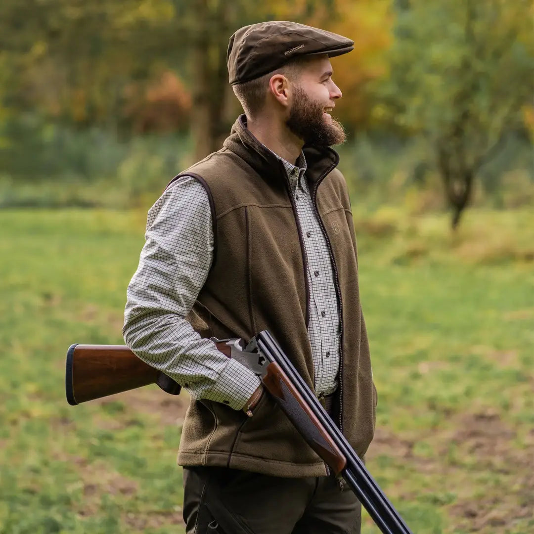 Person in hunting gear holding a shotgun with Deerhunter Eagle Fleece Waistcoat