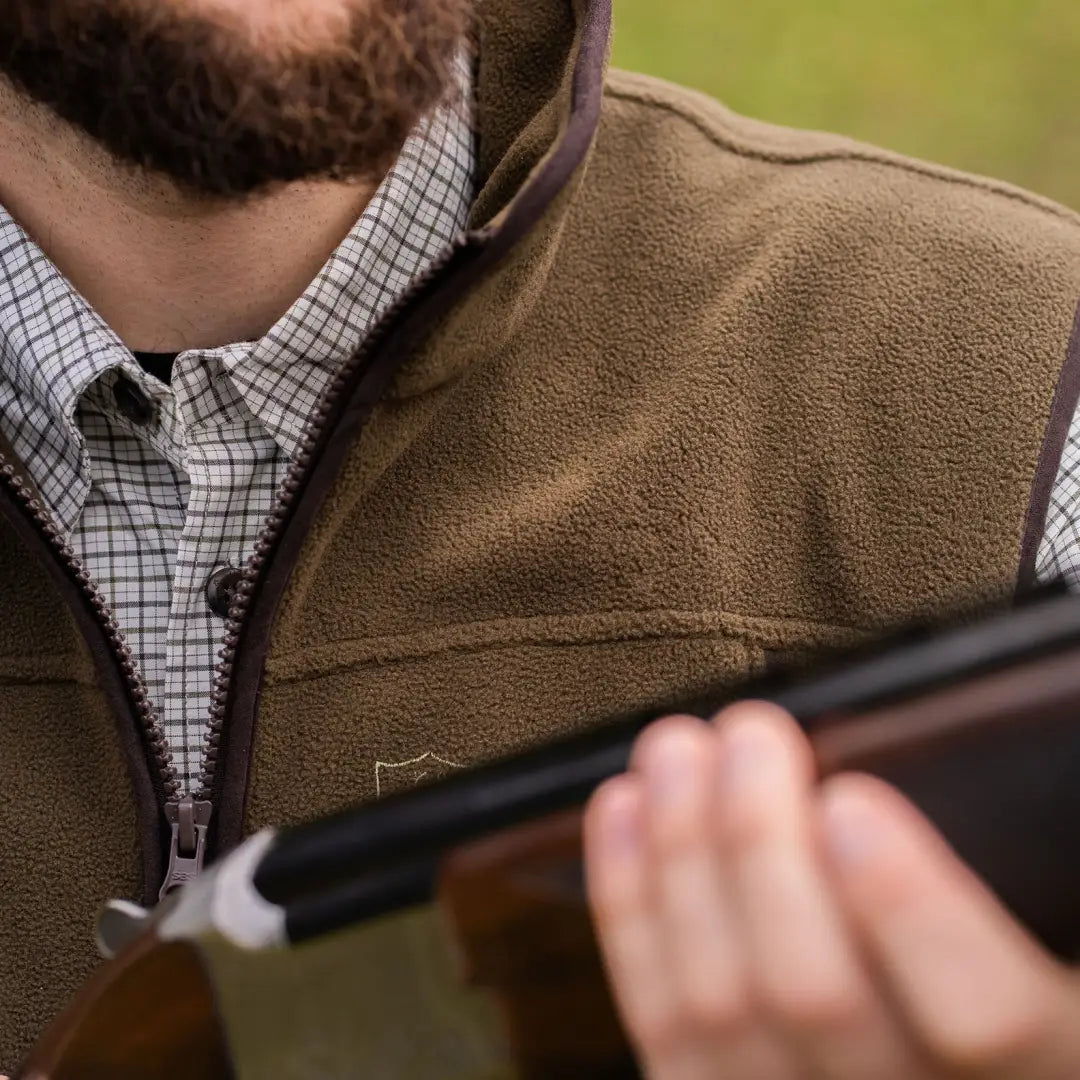 Person in a fleece waistcoat holds a shotgun, showcasing the Eagle Fleece Waistcoat