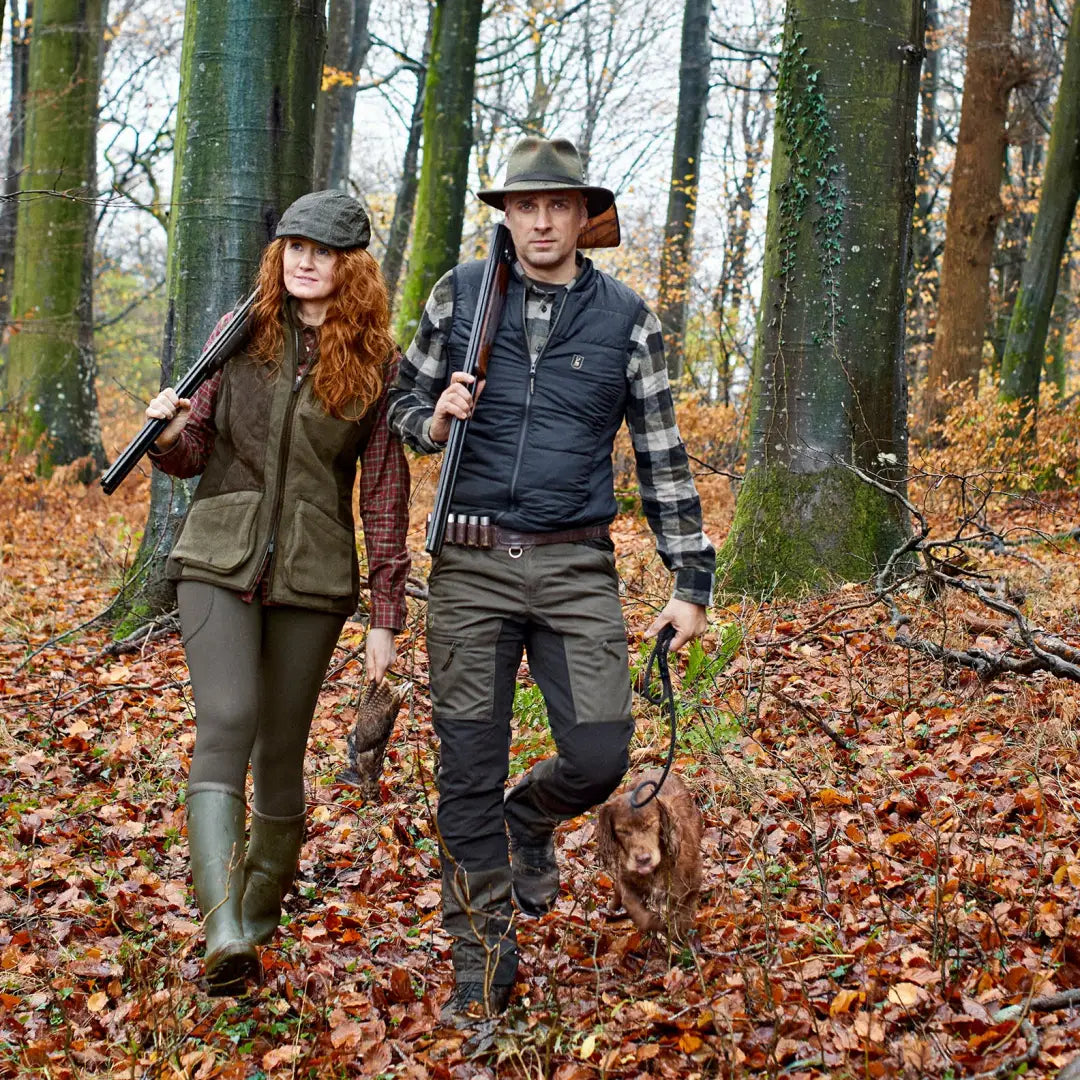 Two hunters in autumn woods wearing Deerhunter Heat Inner Waistcoat with shotguns