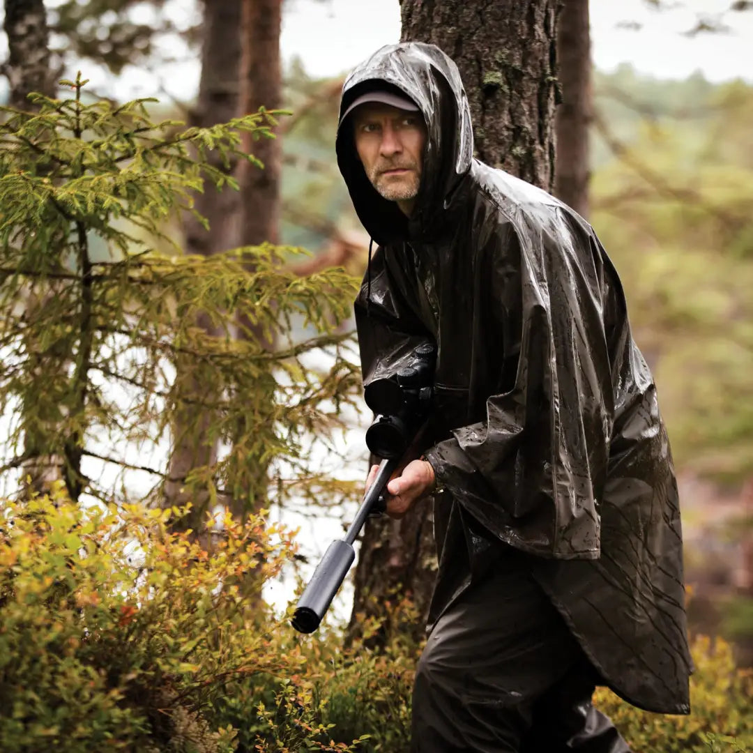 Person in a dark raincoat exploring the forest, perfect for high seat hunting