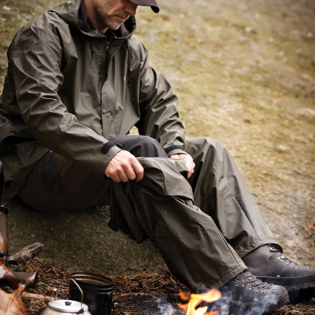 Person in Deerhunter Hurricane Rain Trousers chillin’ by the campfire outdoors