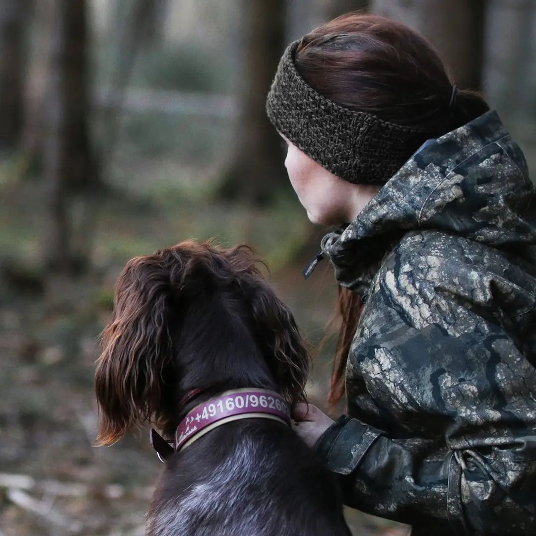 Person in camouflage with a dog in the forest wearing a nice-looking headband