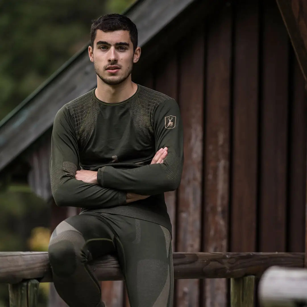 Young man in dark green military-style clothing showcases Deerhunter underwear set