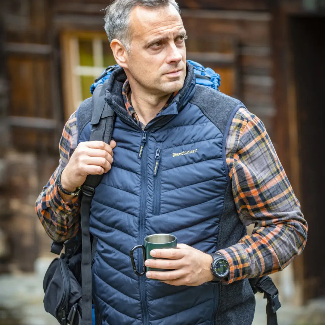 Middle-aged man in a Deerhunter Moor Padded Vest, holding a travel mug, stylish look