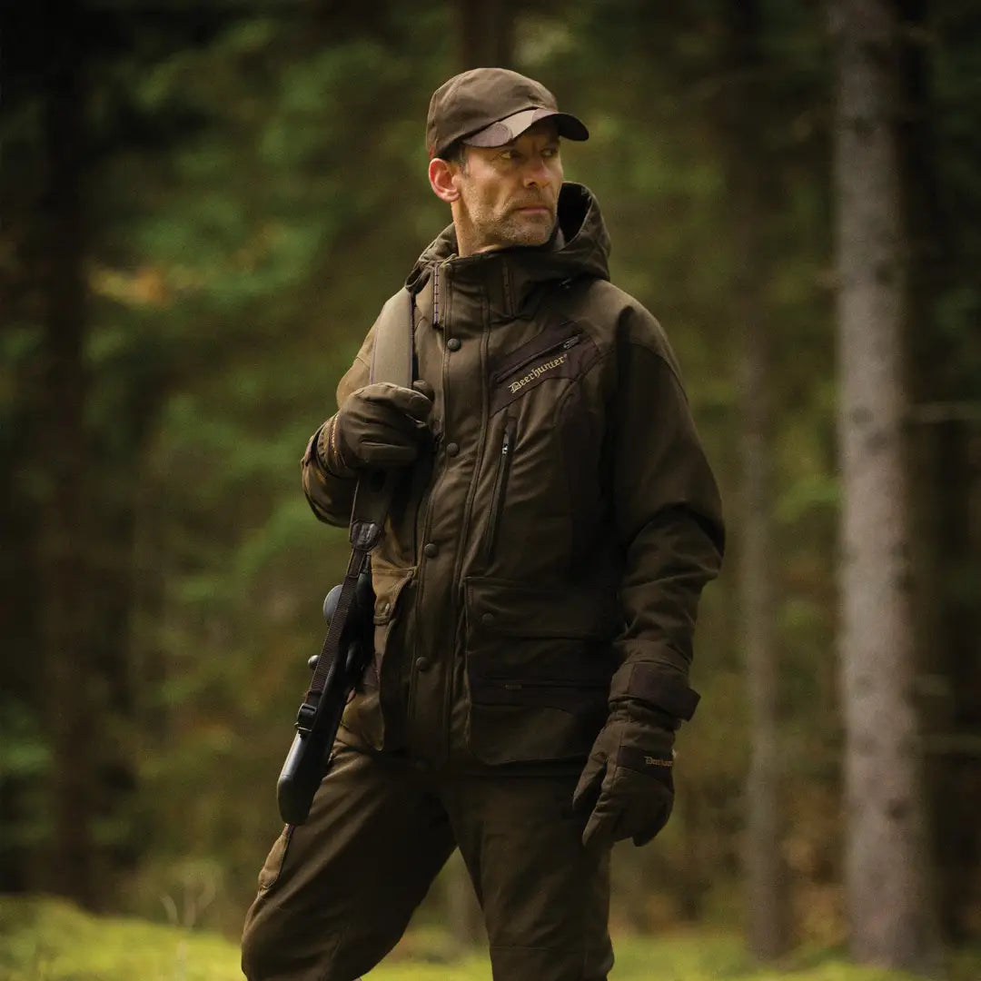 Man in Deerhunter Muflon Jacket sporting outdoor tactical gear in a forest