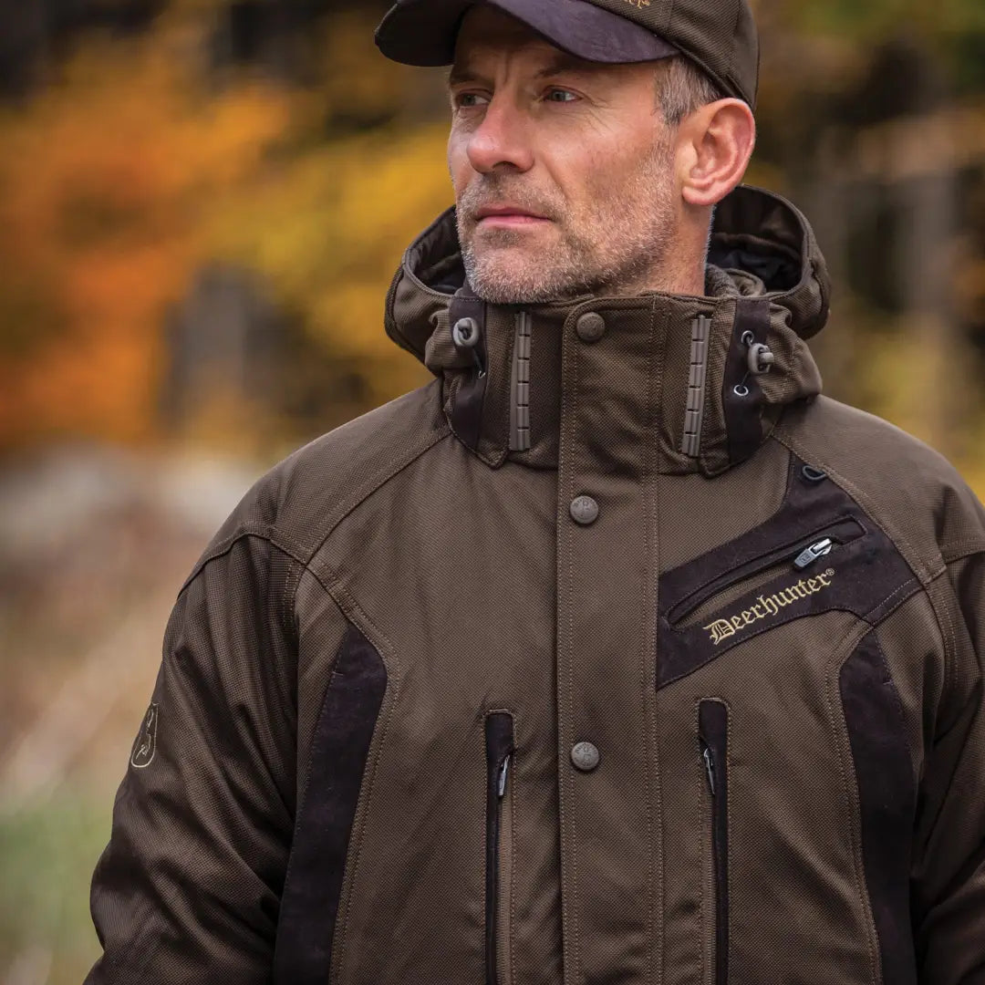 Middle-aged man in dark Deerhunter Muflon Jacket and baseball cap outdoors