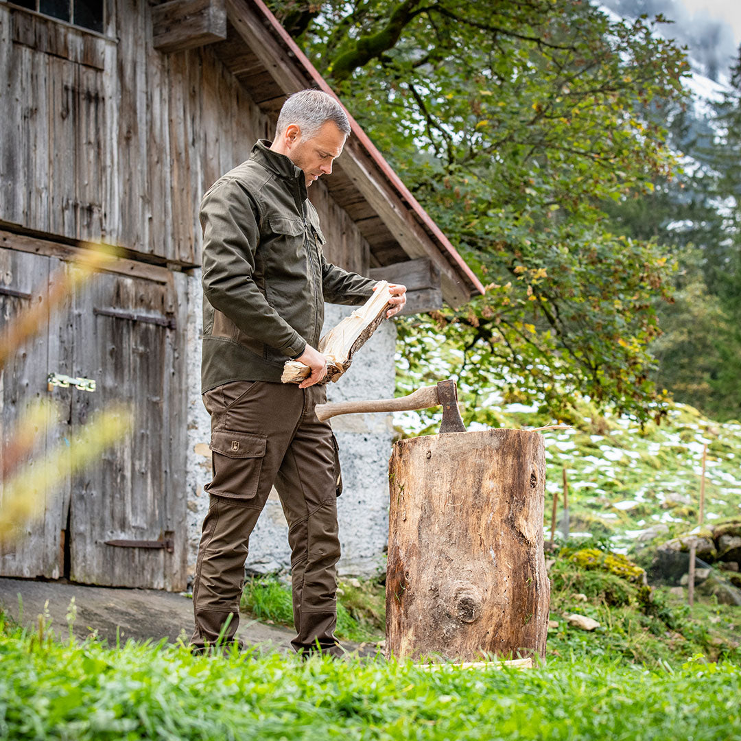 Man splitting wood wearing Rogaland Stretch Trousers for ultimate comfort and mobility