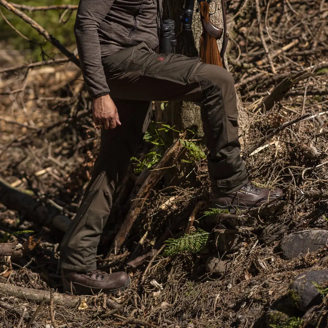 Pair of legs in Deerhunter Rogaland Stretch Trousers on rocky forest terrain