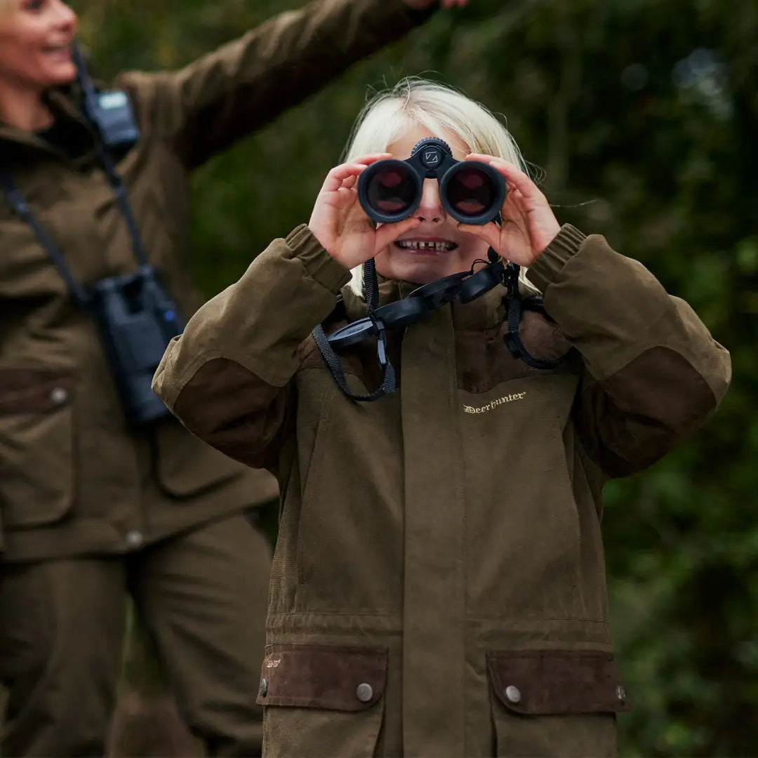 Child exploring the outdoors in a Deerhunter Youth Eagle Winter Jacket with binoculars