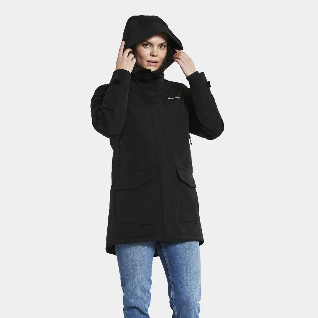 Black hooded Didriksons Frida Womens Parka 6 over blue jeans with taped seams