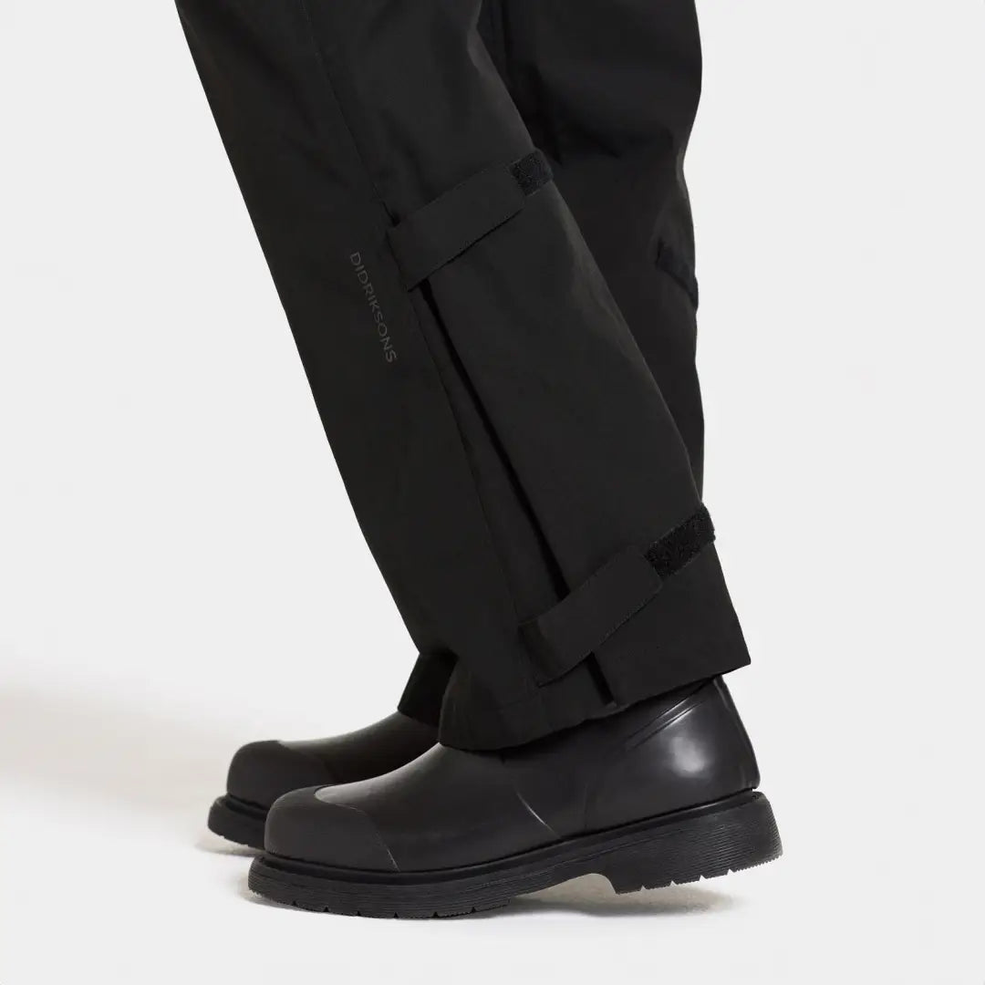 Black leather boots with thick soles paired with Didriksons Grit Womens Rain Pants 2