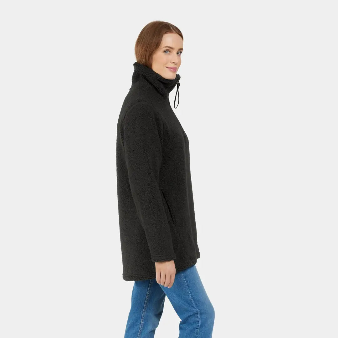 Woman in a black turtleneck jacket with blue jeans showcasing Didriksons Marina Half Zip Fleece