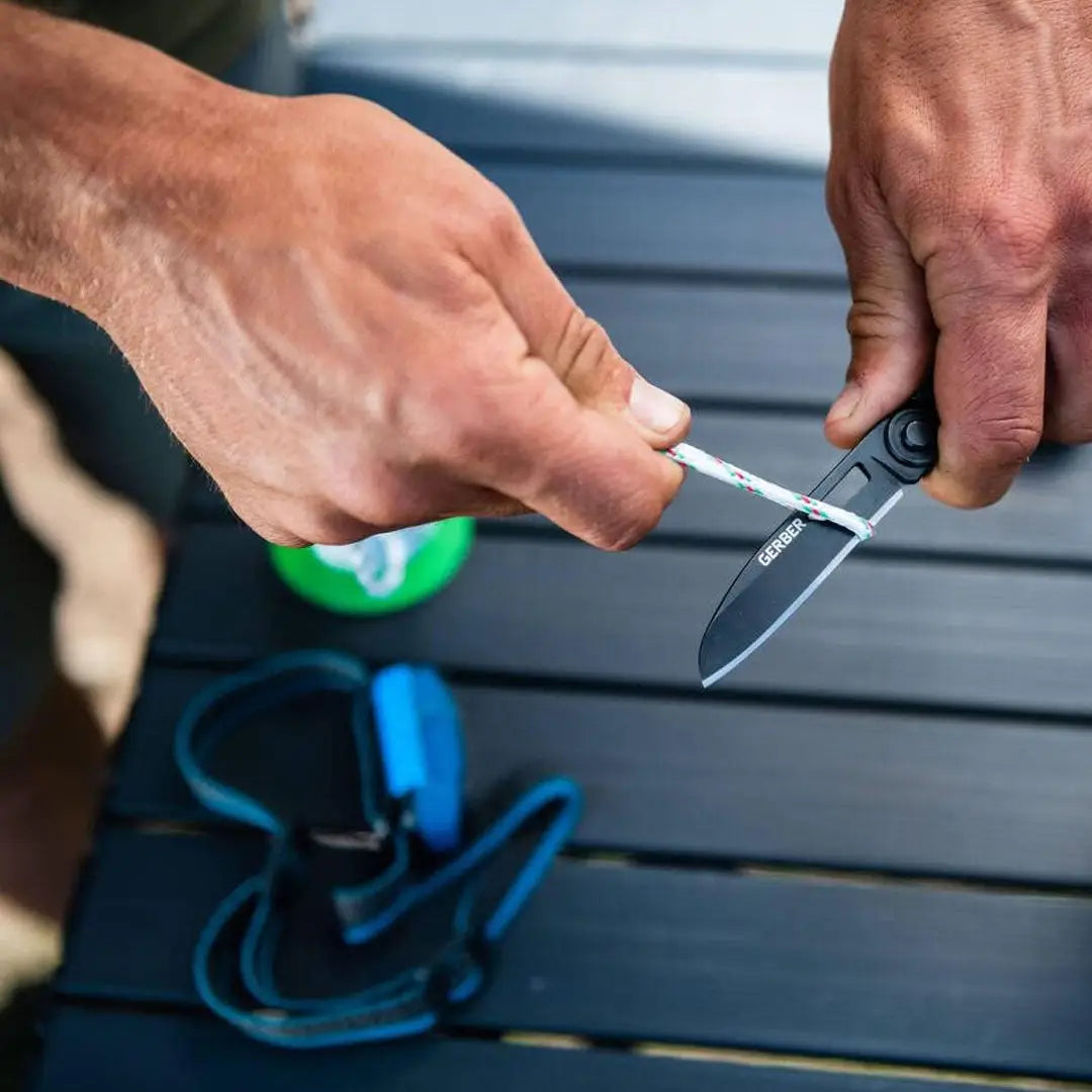 Hands opening a Gerber Armbar Scout pocket knife for easy access, perfect for country clothing